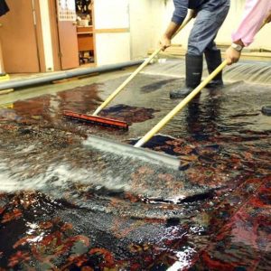 men cleaning oriental rug by hand